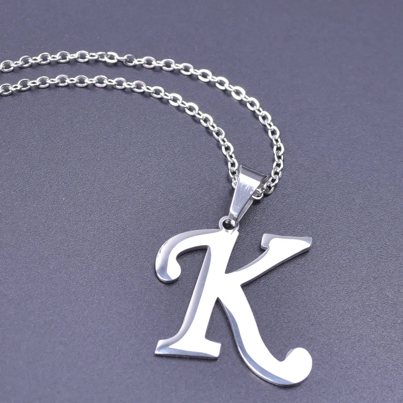 Initial letter pendant held in hand, lifestyle view